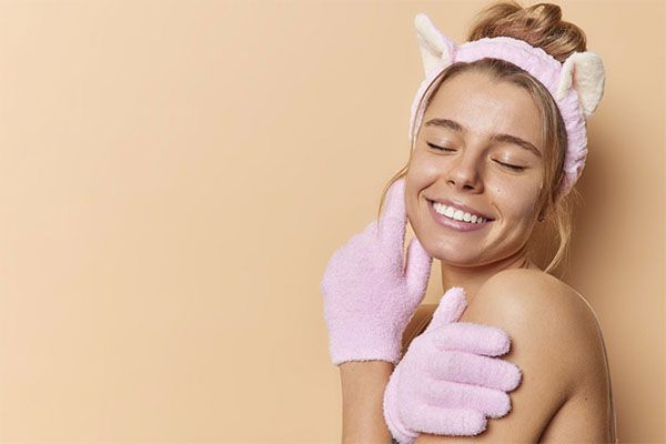 Belle femme à la peau claire avec des gants roses et un bandeau avec des oreilles blanches sur la tête. 