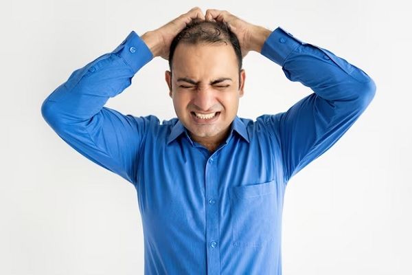 homme d'affaires adulte moyen pleurant tenant la tête dans les mains.