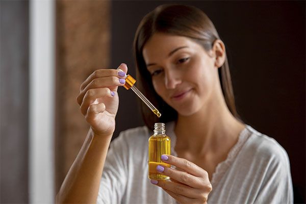 Medium shot of a woman holding a bottle of serum