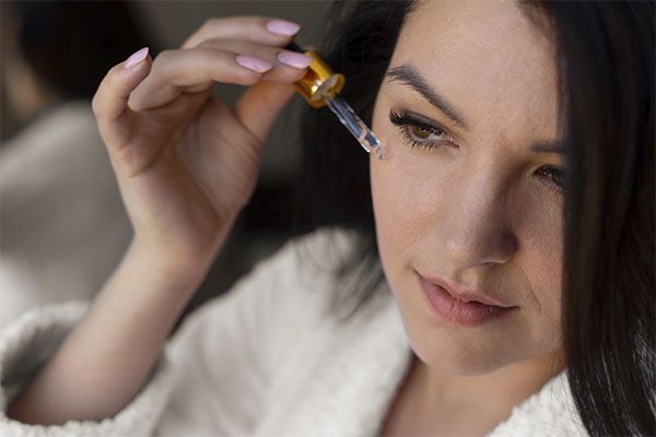 Femme appliquant un sérum pour le visage, gros plan