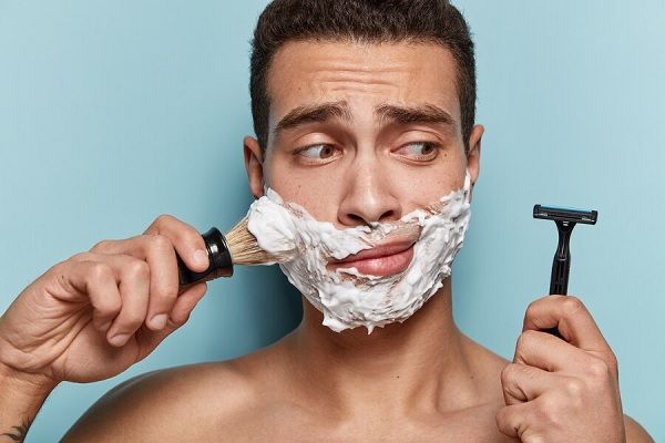 Portrait de jeune homme appliquant de la mousse à raser