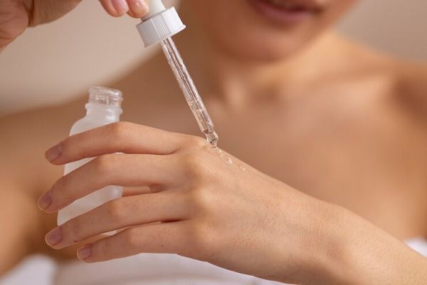 Femme vue de face utilisant du sérum. Tout savoir sur les hydrolats