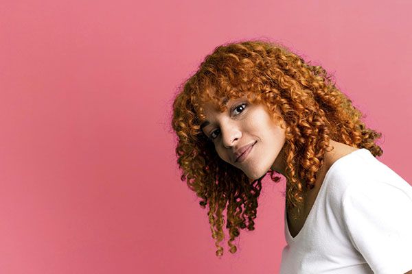 Belle femme aux boucles orange , Prendre soin des cheveux bouclés