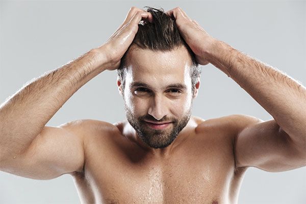 Un homme se peigne les cheveux avec les deux mains, Gel capillaire et chute de cheveux