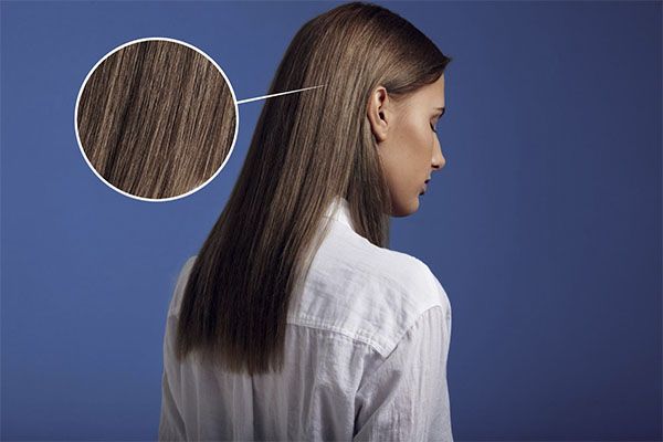 Belle femme avec un zoom sur le cuir chevelu