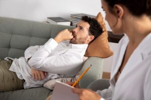Homme allongé sur un canapé en consultation avec un spécialiste 
