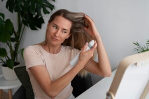 Plan moyen d'une femme utilisant un shampooing sec à la maison