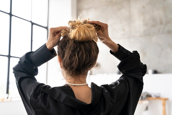 Jeune femme avec une coiffure en chignon en désordre