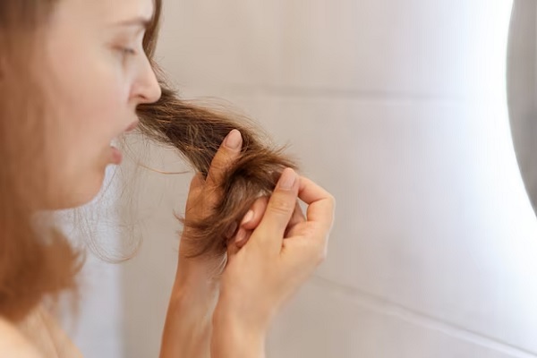 Portrait de profil en gros plan d'une femme étonnée et bouleversée regardant ses cheveux secs, ayant des problèmes, doit changer de shampoing ou de traitement spécial à la clinique trichologique.
