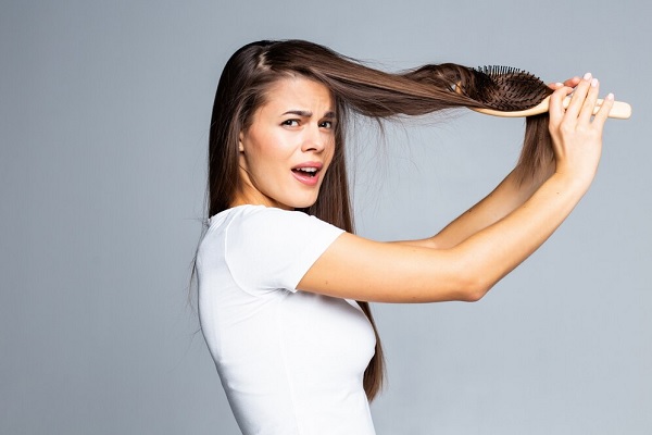 Problèmes de cheveux de jeune femme, cheveux faibles fendus, cheveux emmêlés isolés sur gris