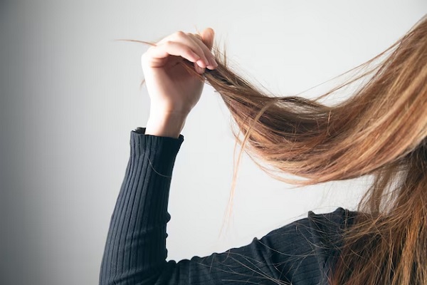 Femme tenant les cheveux abîmés la main