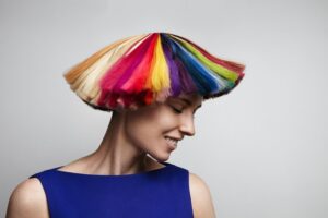Une femme secoue ses cheveux couleur arc-en-ciel, Les colorations naturelles pour les cheveux