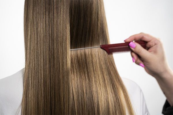Une femme recevant un traitement sur ses cheveux châtains clairs