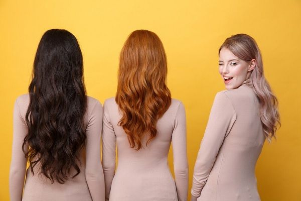 Dame blonde faisant un clin d'œil près des femmes brunes et rousses.