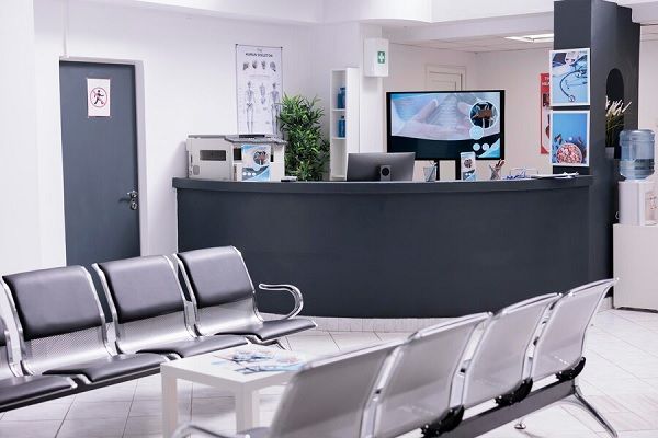 Clinical reception with waiting room in facility lobby, registration counter used for patients with medical appointments.