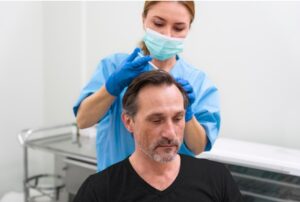 Homme adulte recevant un traitement contre la perte de cheveux, prothèse capillaire Technique FAS