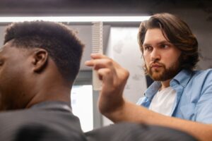 Vue latérale d'un homme se faisant couper les cheveux, les meilleures coupes de cheveux pour les chauves