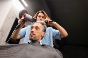 Plan moyen d'un homme se faisant couper les cheveux