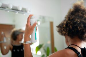 Vue latérale d'une femme utilisant un shampoing sec