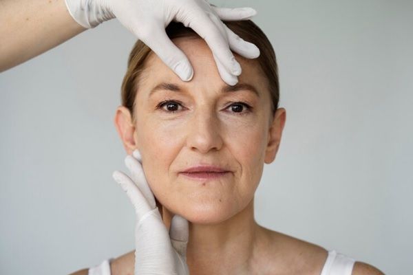 femme avec les mains autour de son visage montrant des poches sous les yeux