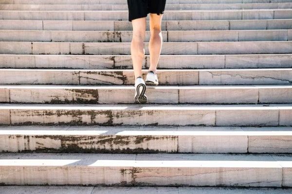 les jambes de l'homme qui montent les escaliers. Exercices pour améliorer la résistance physique