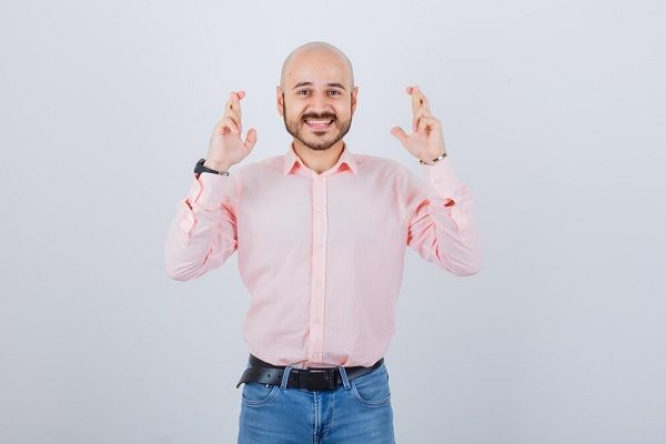 Portrait d'un jeune homme joyeux. Quelle est la relation entre la greffe de cheveux et le bonheur 