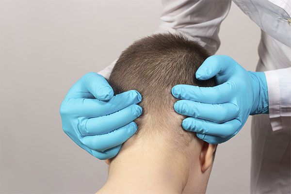 médecin mains sur la tête du patient. Quels sont les effets secondaires d'une greffe de cheveux 