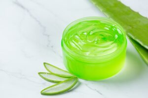 Crème cosmétique à l'aloe vera sur surface blanche, Comment choisir entre un gel capillaire ou une cire