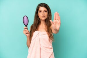 L'air sérieux, la paume ouverte faisant un geste d'arrêt.