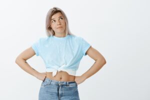 Portrait d'une jeune fille blonde peu sûre d'elle, posant en studio. 