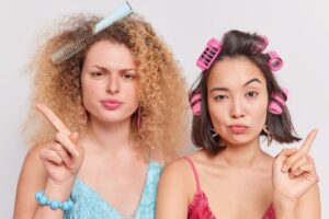 Des femmes sérieuses secouent les doigts pour dire non et regardent attentivement la caméra. débarrasser des pellicules chez les femmes